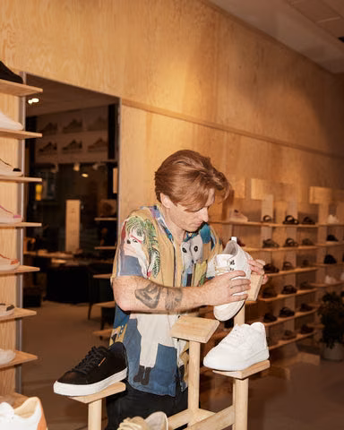 En i teamet gjør klar en hvit sneaker i butikken i Oslo