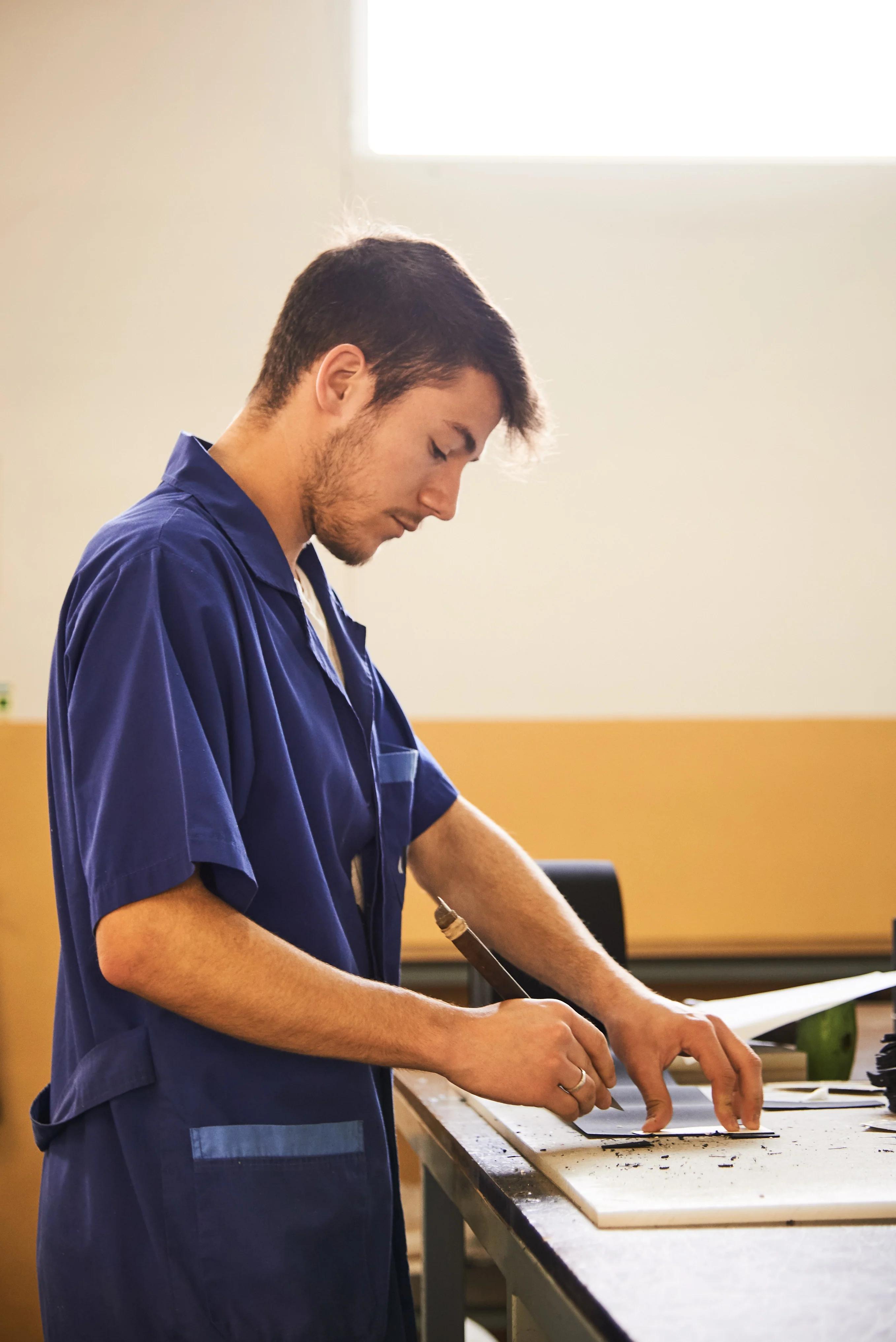 A New Movements craftsperson working with footwear materials